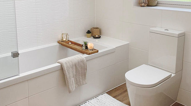 Image of a medium-sized bathroom. Featuring a standard shower bathtub, toilet and white tiled walls.